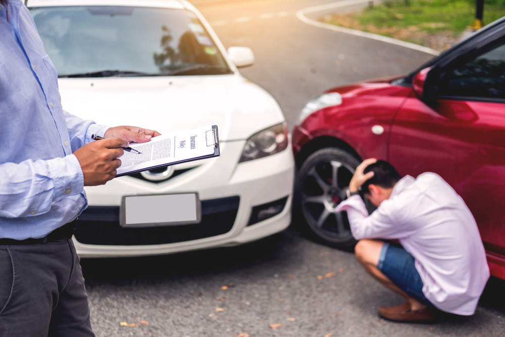 cómo elegir el mejor seguro de auto | agente de seguro vehicular revisando un accidente de tránsito